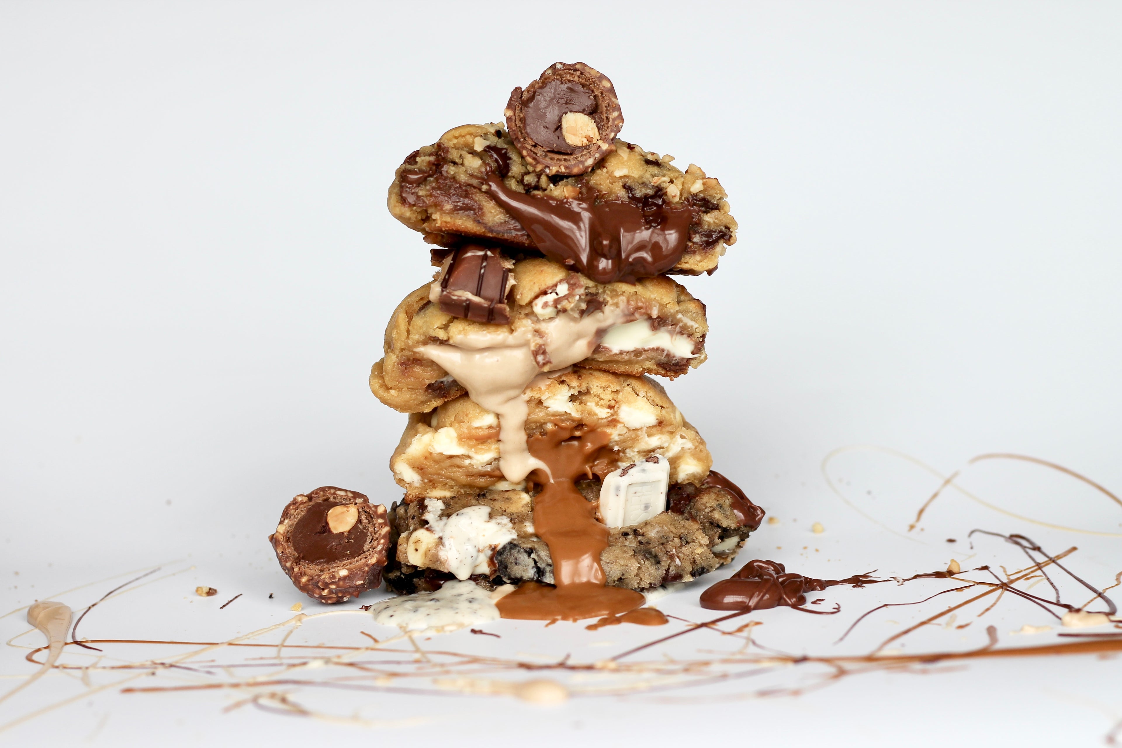 Stack of gooey, thick New York-style cookies from Dolly’s Dough, in Nutella, Biscoff, Kinder, and Oreo flavors. Handmade and loaded with chocolate chips, perfect for gifting or indulging. Taste the best NYC cookie flavors with nationwide UK delivery